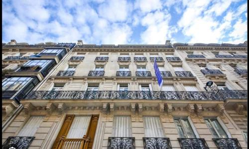 un bâtiment arborant un drapeau à l'avant dans l'établissement L'avenue Montaigne, à Paris