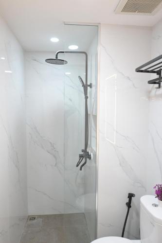 a glass shower in a bathroom with a toilet at Apartment Medan Podomoro City Deli by OLS Studio in Medan
