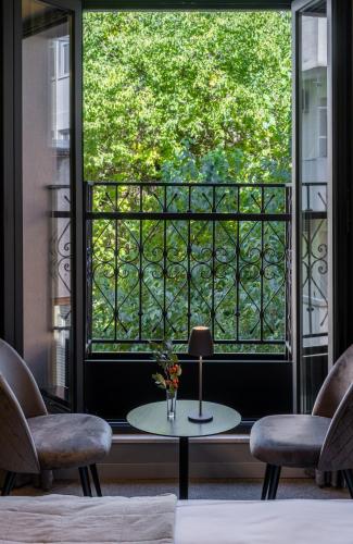 a room with a large window with a table and two chairs at Sentro Boutique Hotel in Sofia