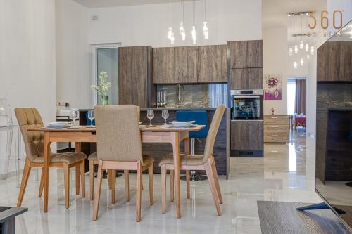 a kitchen and dining room with a wooden table and chairs at Stunning 2BR Penthouse with terrace in Mosta by 360 Estates in Mosta