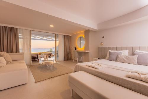 a bedroom with a large bed and a living room at La Kumsal Hotel in Kaş