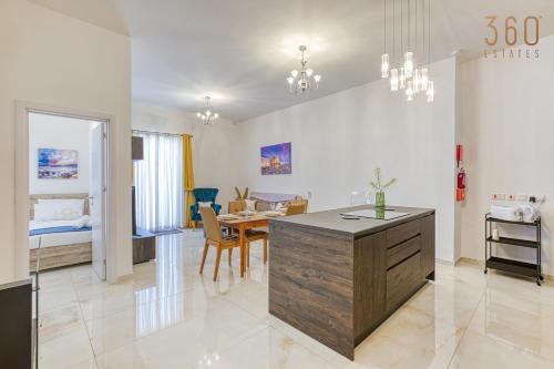 a living room with a kitchen and a dining room at Stunning 2BR Penthouse with terrace in Mosta by 360 Estates in Mosta