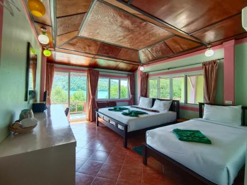 a bedroom with two beds and a table in a room at Phi Phi View Point Resort in Phi Phi Don