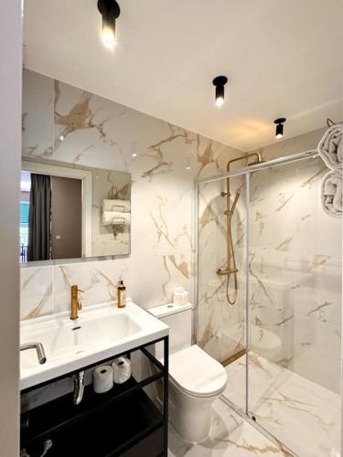 a bathroom with a sink and a toilet and a shower at Suites Do Carmo in Funchal