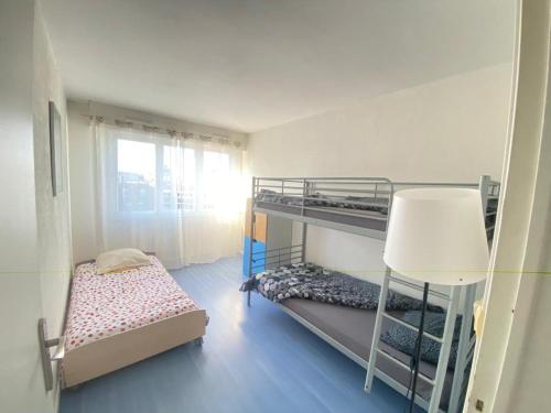 une petite chambre avec deux lits superposés et une fenêtre dans l'établissement Appartement familial proche de Paris, au Bourget