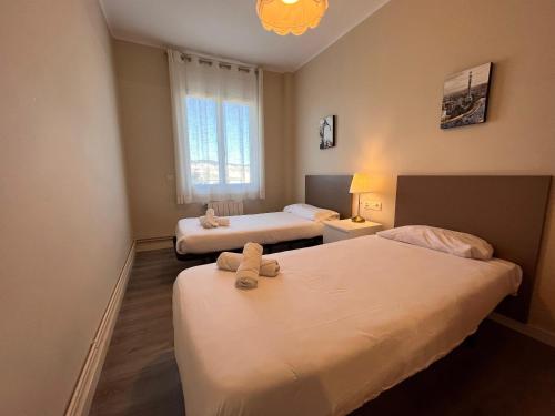 a hotel room with two beds and a window at RIUS - Apartments & one Penthouse with private terrace in Montjuic in Barcelona