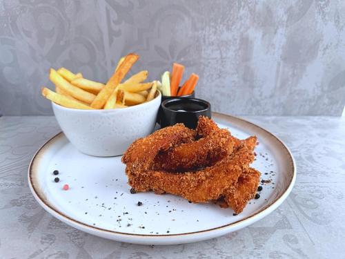 a plate with fried food and a bowl of fries at Hotel Fabrica in Liberec