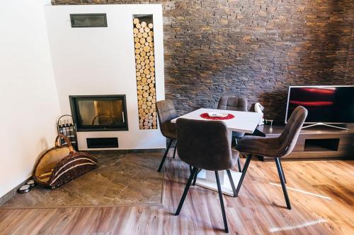 a dining room with a table and chairs and a fireplace at Apartmány pri Jaskyni - Bystrá in Bystrá
