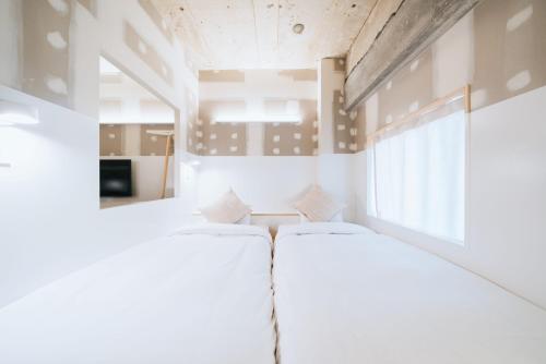 two beds in a room with a window at Of Hotel in Sendai