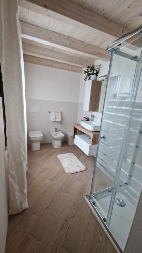 a bathroom with a toilet and a glass shower at La casa delle rose 3 in Giba