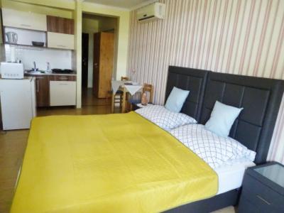 a bedroom with a large bed with a yellow blanket at Alíz Vendégház in Békéscsaba