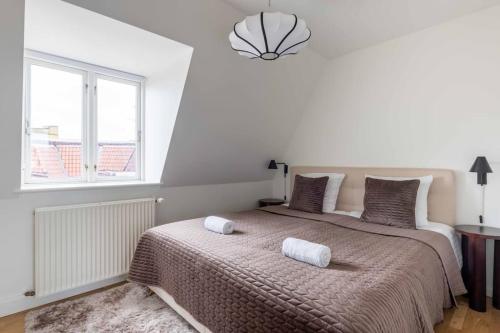 a bedroom with a large bed with two towels on it at 2BR with Amazing City Skyline View in Copenhagen