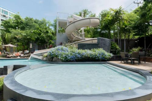 a swimming pool with a water slide in a resort at Luxury 70Sqm 2 BR Condo Next to Walking Street in Pattaya Central