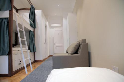 a bedroom with a bed and a couch and bunk beds at Hostel Karavan Inn in Belgrade
