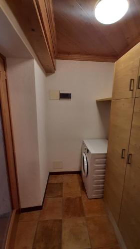 a small bathroom with a washer and dryer at CAMPO BASE CADORE con parcheggio auto e garage moto in Valle di Cadore