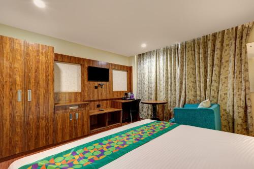a bedroom with a bed and a desk and a tv at Treebo Blak & Wite Rk Beach in Visakhapatnam