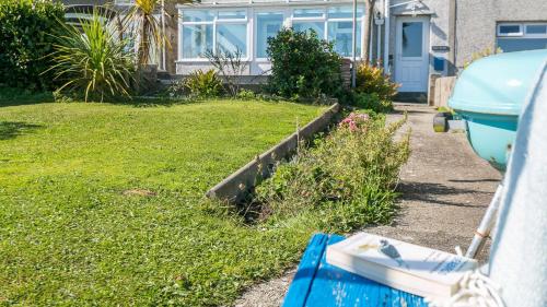 a house with a boat parked in the yard at 7 Seaview in Moelfre