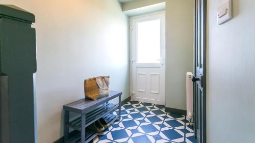 a hallway with a door and a blue and white floor at 7 Seaview in Moelfre