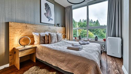 sypialnia z łóżkiem i dużym oknem w obiekcie Apartament SPA 56 Resort Kozubnik blisko Szczyrk - 5D Apartamenty w mieście Porąbka