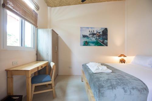 The Hidden Lagoon Resort - Exclusively for Adults في شاطئ راوايْ: غرفة نوم بها سرير ومكتب ونافذة