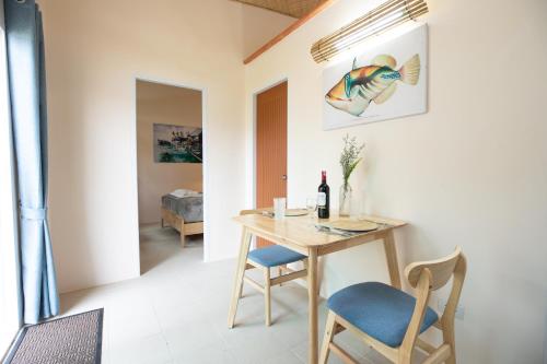 a dining room with a table and a blue chair at The Hidden Lagoon Resort - Exclusively for Adults in Rawai Beach
