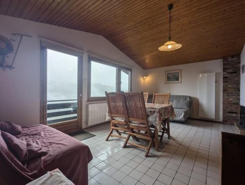 un salon avec une table, des chaises et un canapé dans l'établissement Le Petit Chalet Bellevue - COSY calme parking, à La Bresse