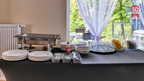 a black table with plates and dishes on it at Apartament SPA 56 Resort Kozubnik blisko Szczyrk - 5D Apartamenty in Porąbka