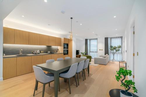 a kitchen and dining room with a table and chairs at Kings Cross - Luxury 3 Bed Apartment, Private Balcony in London