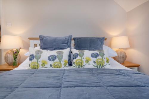 - une chambre avec un lit bleu et 2 oreillers dans l'établissement Dipple Mill Cottage, à Bideford