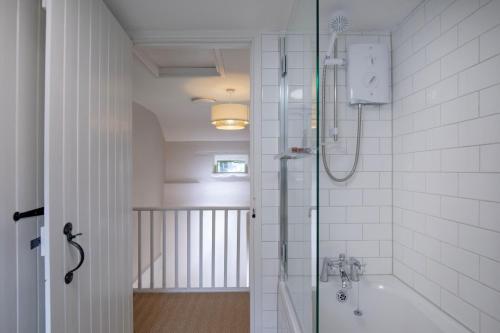 La salle de bains est pourvue d'une douche à l'italienne et d'une baignoire. dans l'établissement Dipple Mill Cottage, à Bideford