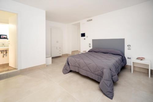 a bedroom with a purple bed and a bathroom at Il Tesoro Smart Suite & SPA in Naples
