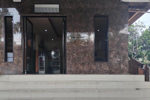 a building with glass doors on the side of it at RedDoorz at Oxy Residence Manado in Malalayang