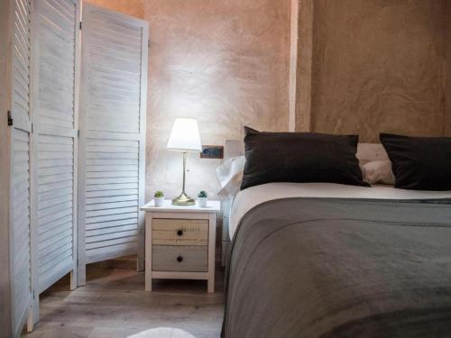 a bedroom with a bed and a lamp on a night stand at AbenRazin Turístico Guadalaviar in Albarracín