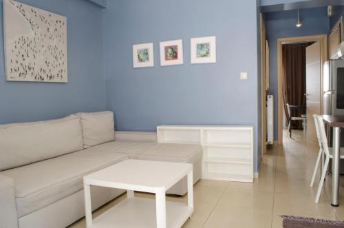 a living room with a white couch and a table at Thess1home Mistral in Thessaloniki