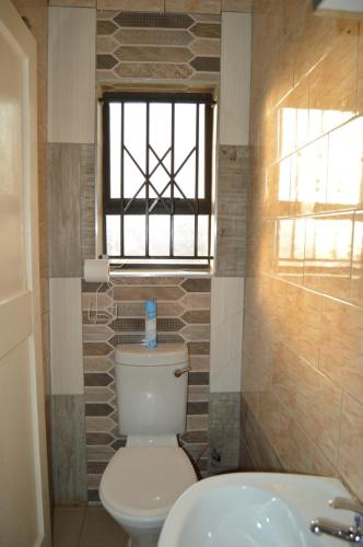 a bathroom with a toilet and a sink and a window at The View Guestlodge in Orkney