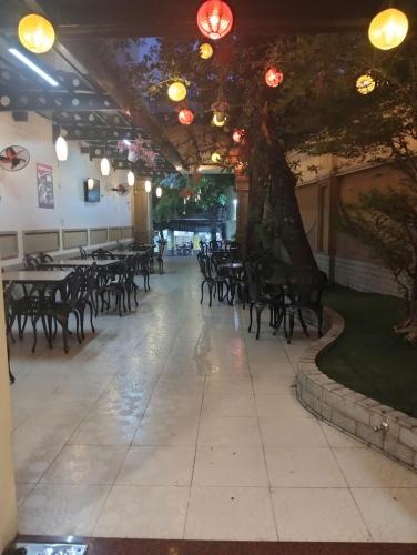 a large room with tables and chairs and a tree at THANH TAI HOTEl 1 in Ho Chi Minh City