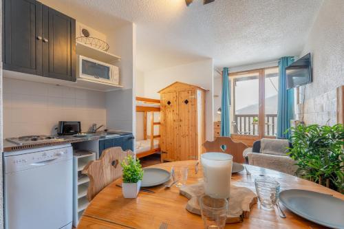 une cuisine et un salon avec une table en bois, une cuisine et une salle à manger dans l'établissement Ski In-Out - Heart of Val Thorens Cosy Apartment, WiFi 1003, à Val Thorens