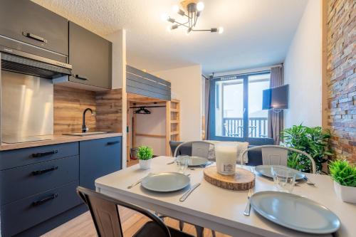 une cuisine et une salle à manger avec une table et des chaises dans l'établissement Ski In-Out - Heart of Val Thorens Spacious Apartment, WiFi 1001, à Val Thorens