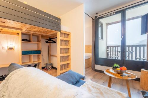 un salon avec un canapé et une grande fenêtre dans l'établissement Ski In-Out - Heart of Val Thorens Spacious Apartment, WiFi 1001, à Val Thorens