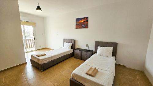una camera da letto con due letti e una finestra di Sky Ward City Rooms, 150m from Chabad Lubavitch a Larnaka