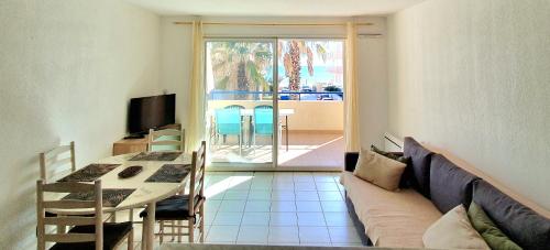 un salon avec un canapé et une table dans l'établissement T2 Écume Vue Mer Terrasse Parking, à Palavas-les-Flots