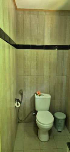 a bathroom with a toilet with a flower on it at Kot Babi in La Digue