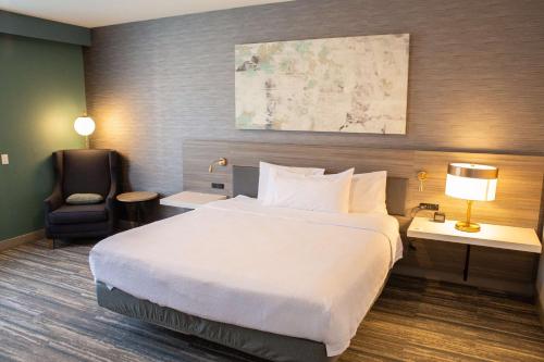 a hotel room with a large bed and a chair at Hilton Garden Inn Montebello / Los Angeles in Montebello
