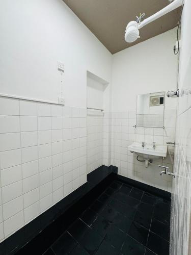 a white bathroom with a sink and a mirror at Havelock City Hostel, Colombo in Colombo