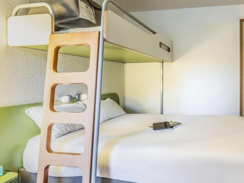 a bedroom with a bunk bed with a bunk bedutenewayewayangering at ibis budget Compiègne Centre-Ville in Compiègne