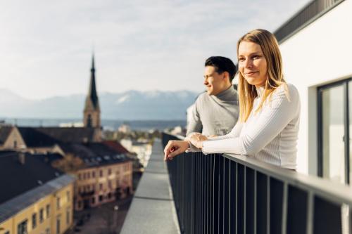 a man and woman standing on the ledge of a building at harry's home Villach hotel & apartments in Villach