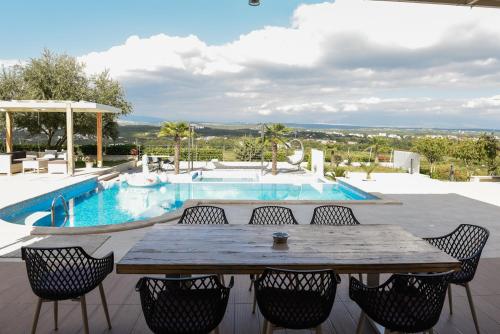 a patio with a table and chairs and a pool at Villa VAND Paradiso in Međugorje