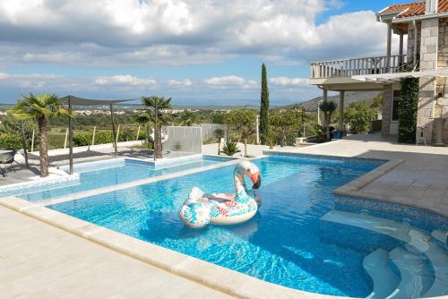 a swimming pool with an inflatable pool noodle in a house at Villa VAND Paradiso in Međugorje