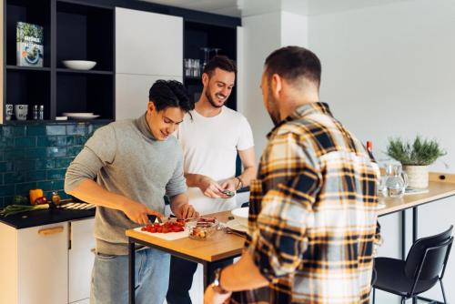 a group of men standing in a kitchen preparing food at harry's home Villach hotel & apartments in Villach