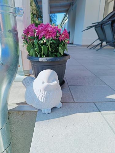 a white bird statue sitting next to a pot of flowers at Búj-Lak Vendégház in Zalaszentmárton